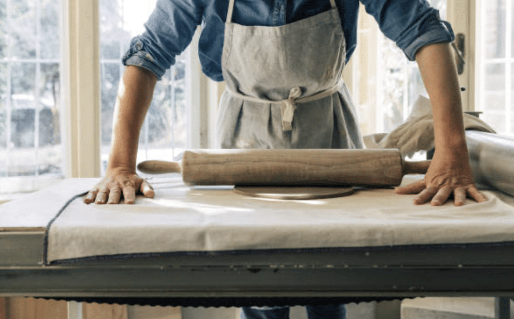 a guy rolling pin and making a dough