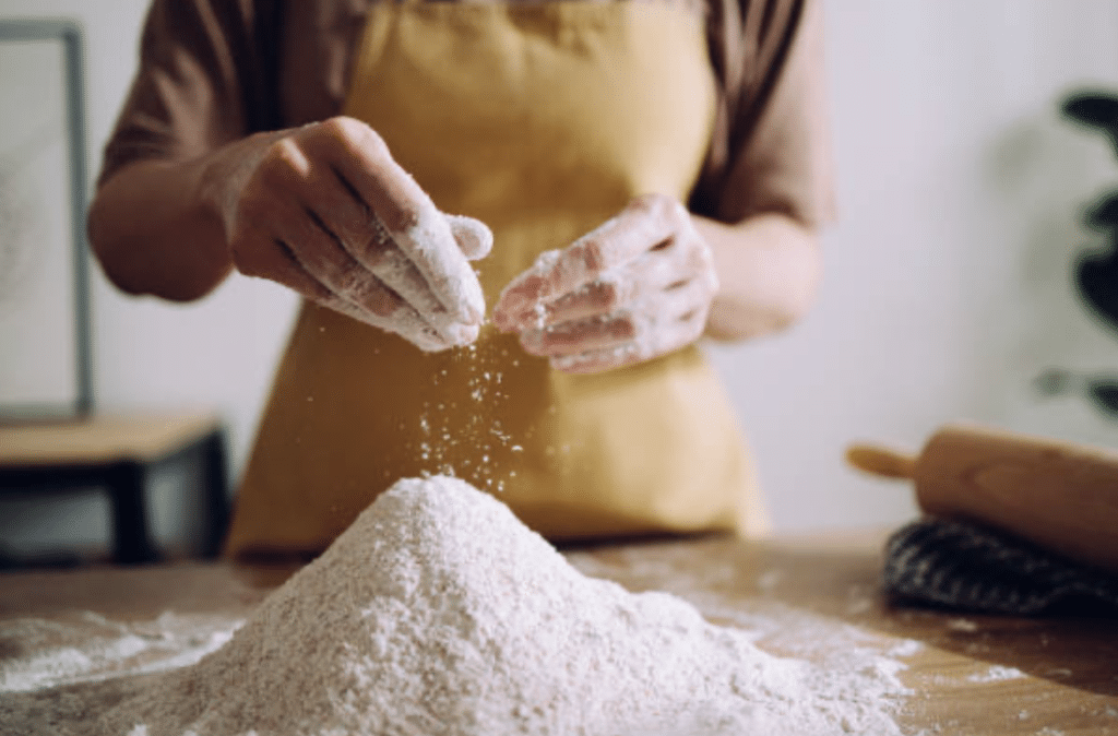 a woman working on the pile of flour